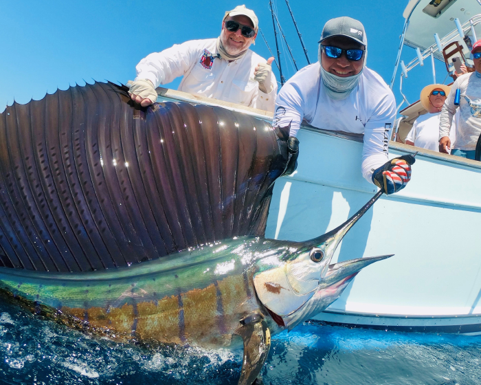 James on a boat with a large swordfish